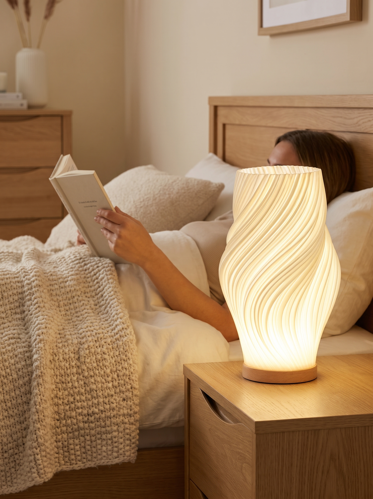 Onda table lamp glowing on a bedside table