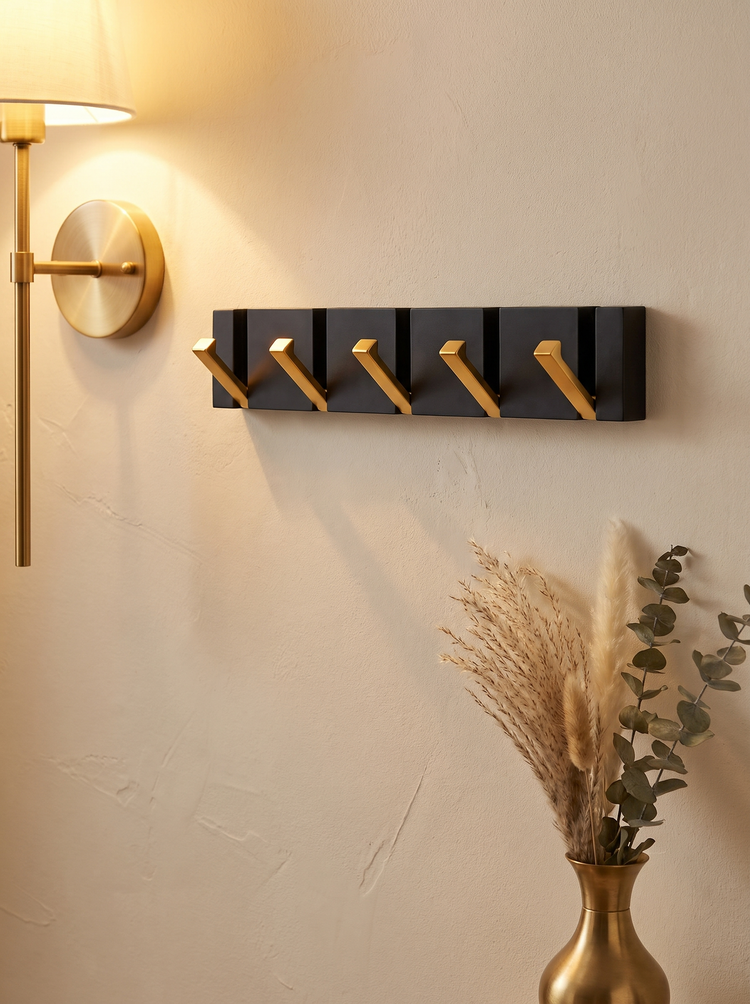 Vela rail with gold hooks under a wall light